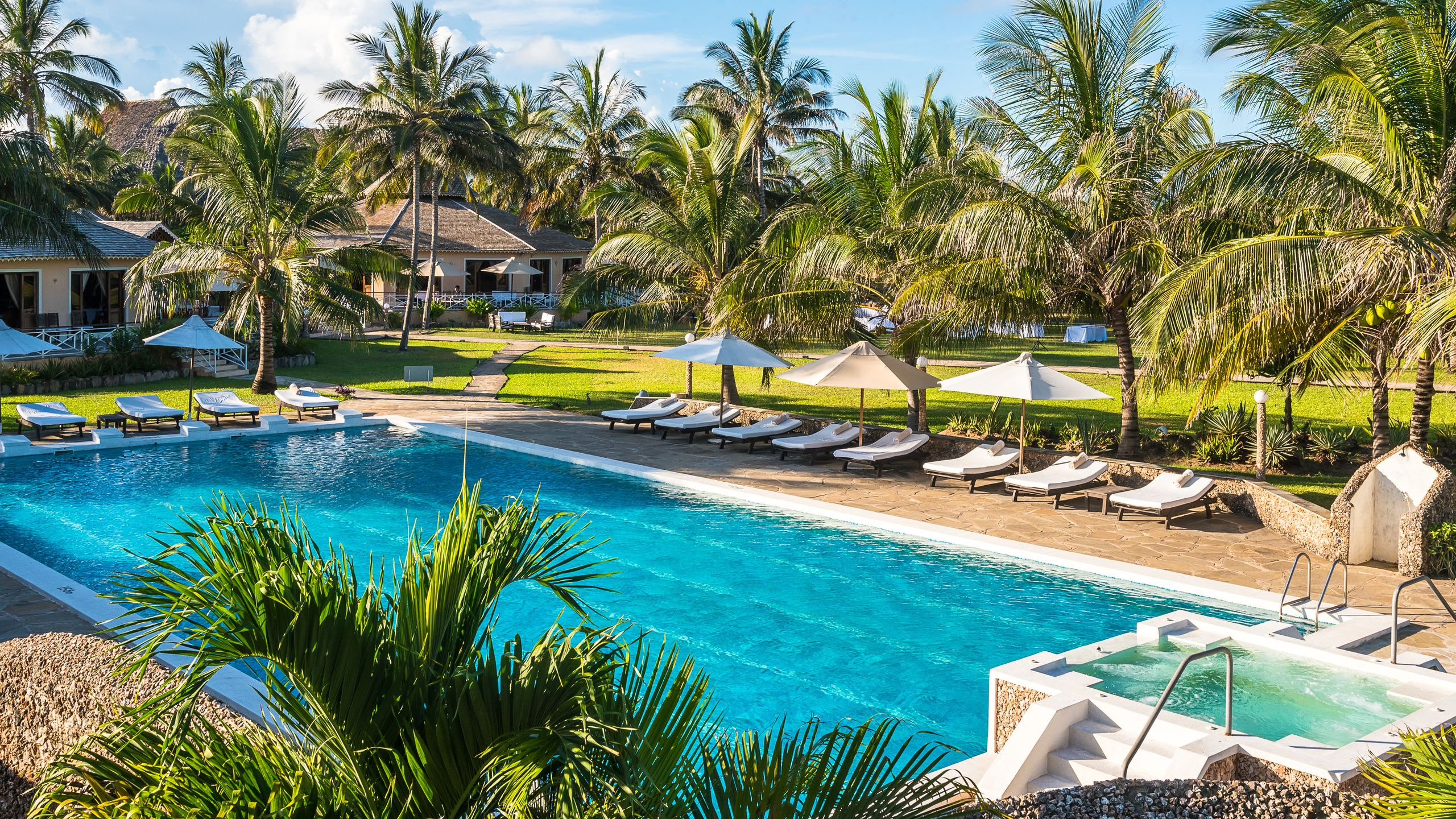 A palm-fringed resort pool overlooking the Indian Ocean coastline in Malindi, Kenya