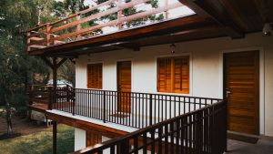 Serene wooden lodge featuring balconies, doors and windows surrounded by lush greenery
