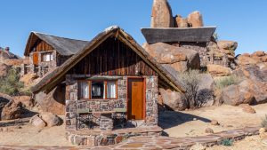 Stone lodge building nestled among rocky escarpment terrain