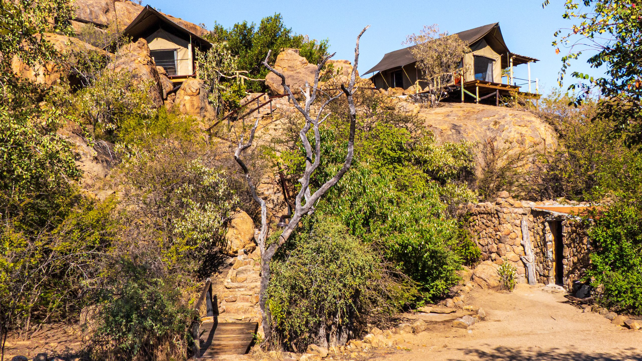 Rustic safari lodge buildings set among rocky, semi-arid scrub typical of northern Kenya
