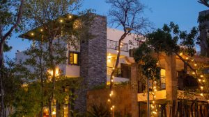 Elegant villa-style lodge with glowing lights among trees at twilight