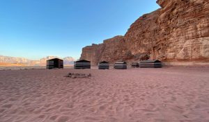 Striped safari tents set on open desert plains, evocative of tented camp accommodation near Amboseli