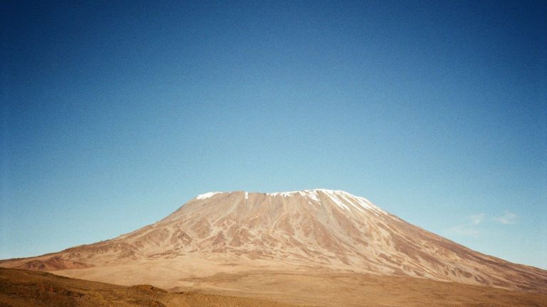 Mount Kilimanjaro's snow-capped summit rising against a clear blue sky