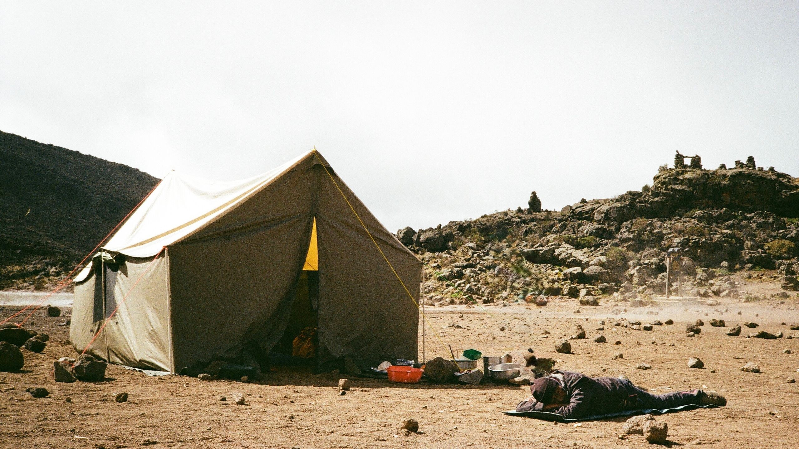 Luxury safari tent set on open ground beneath Mount Kilimanjaro