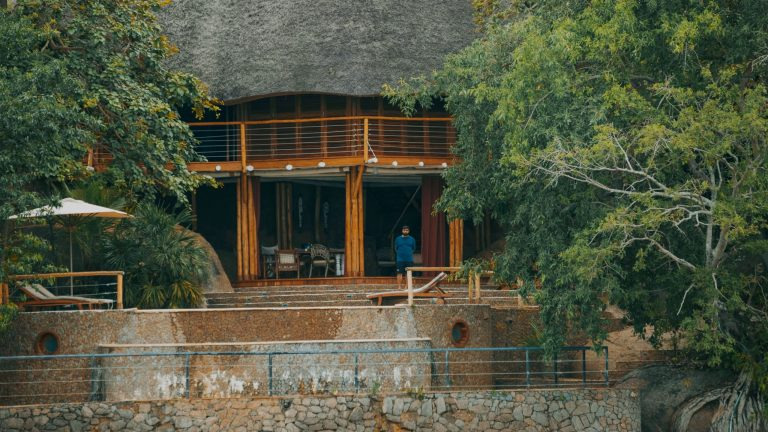 Rustic lakeside lodge structure surrounded by lush trees