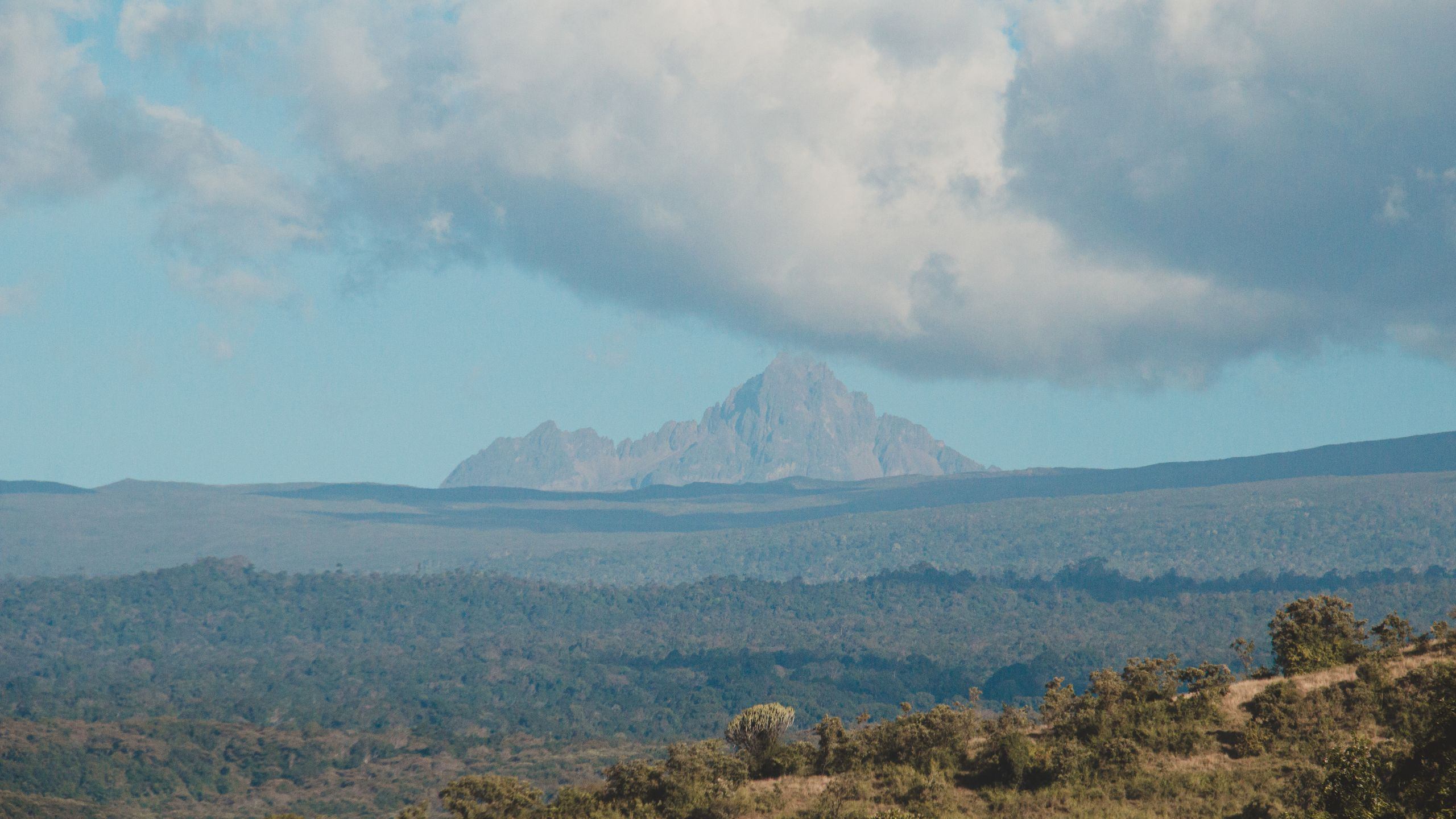 Dramatic rocky mountain peak rising into a cloudy sky in the Kenyan highlands